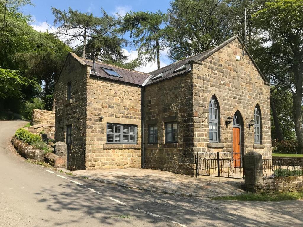 a small brick church with a orange door at The Old Chapel in Ashover