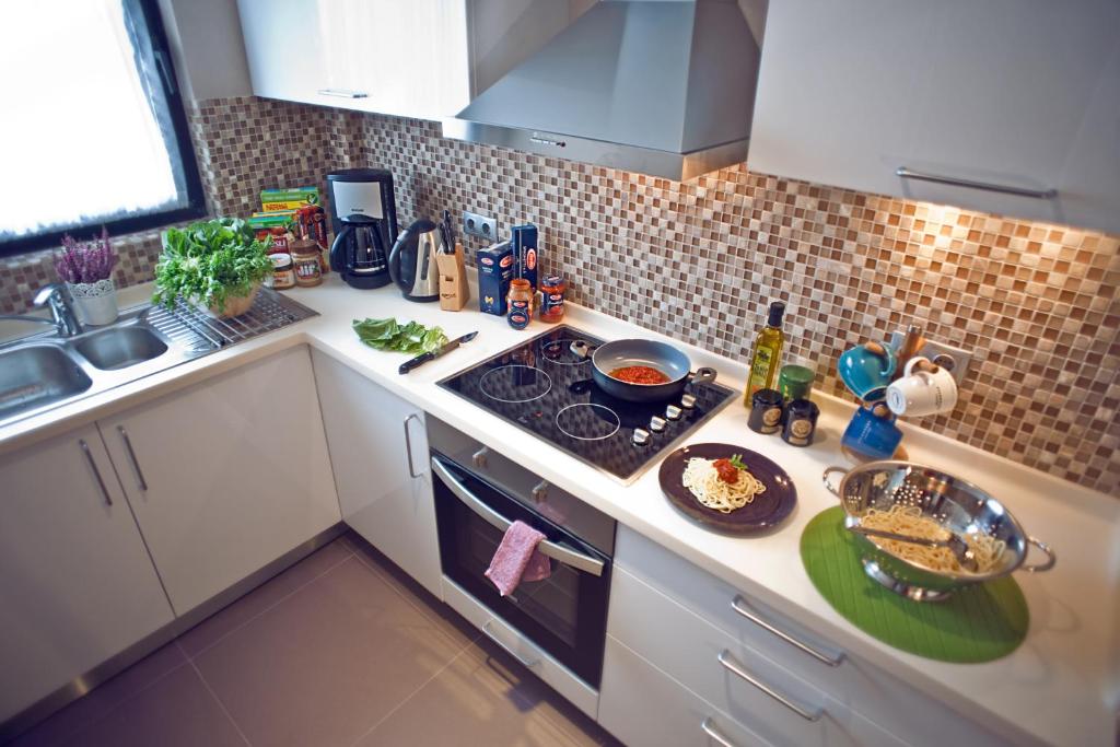 a kitchen with a stove top oven next to a sink at Apart Hotel Best in Ankara