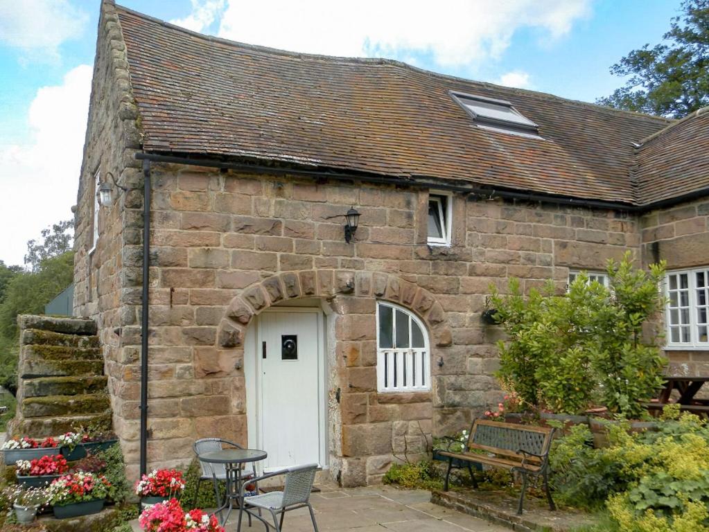 an old stone house with a white door at Shire Cottage in Highpeak Junction