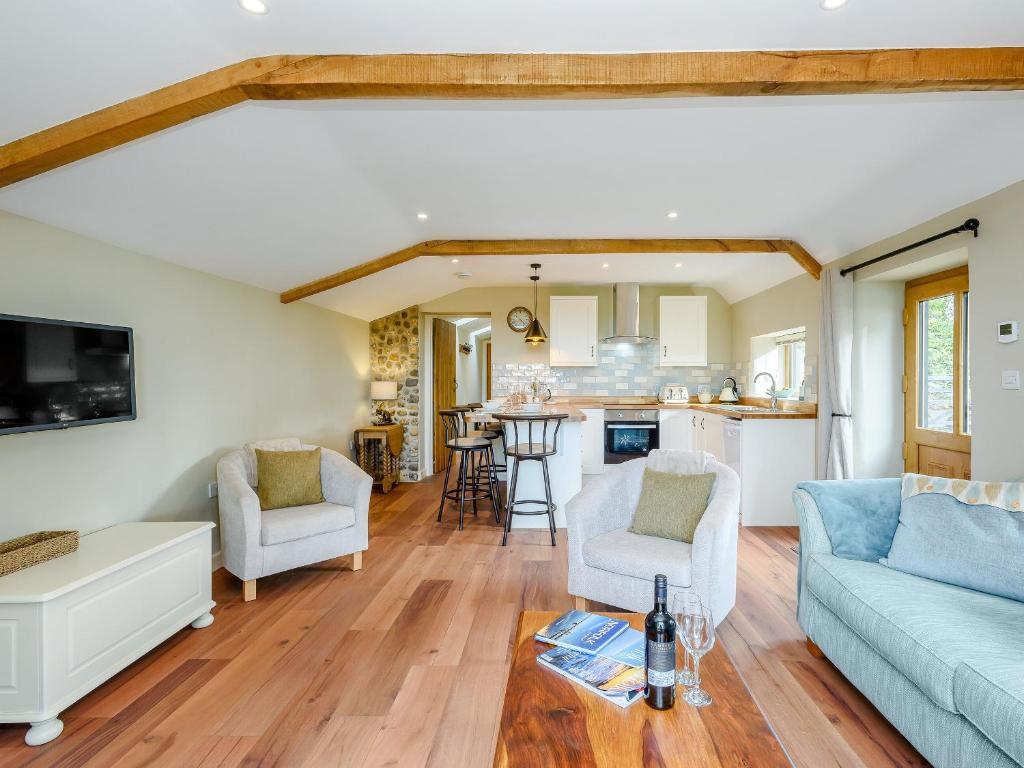 uma sala de estar com um sofá e uma mesa em Stackyard Cottage em Felmingham