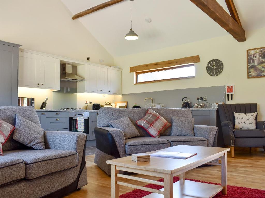 uma sala de estar com dois sofás e uma mesa em Cider Press Barn - Uk12379 em Lydney