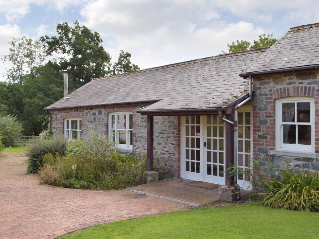 an old stone house with a garage at Cothi Cottage in Llanfynydd