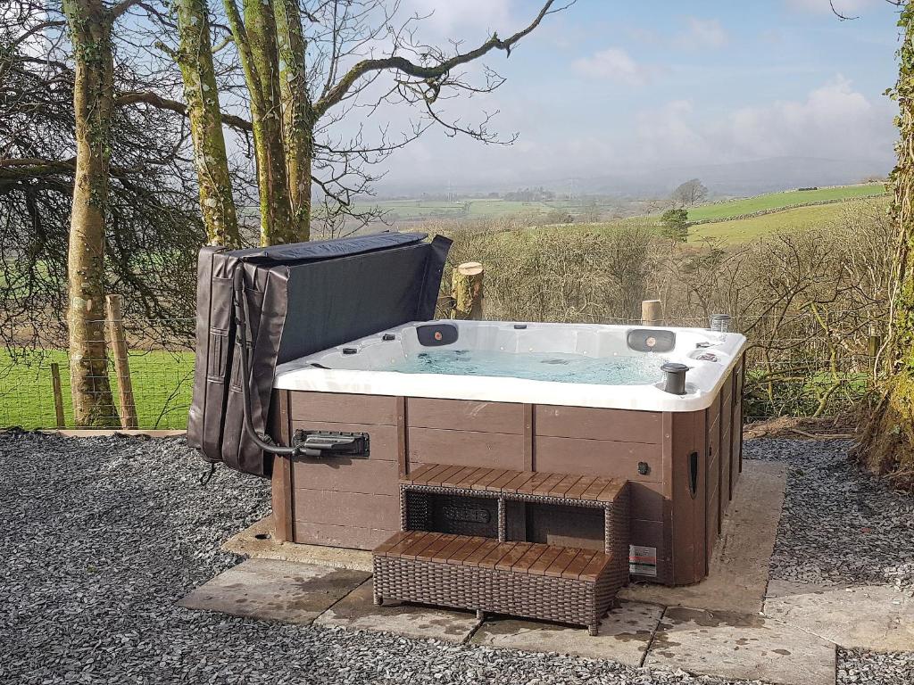 a hot tub sitting in the middle of a yard at Dutch Barn One - Uk12872 in Brynkir