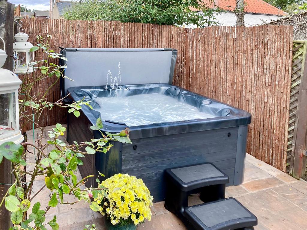 a blue hot tub in a garden with two stools at Well House in Belford