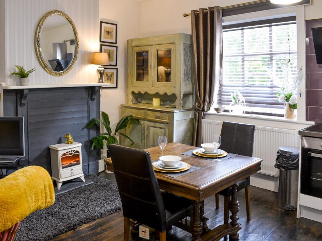 a dining room with a table and a fireplace at The Archway in Newnham