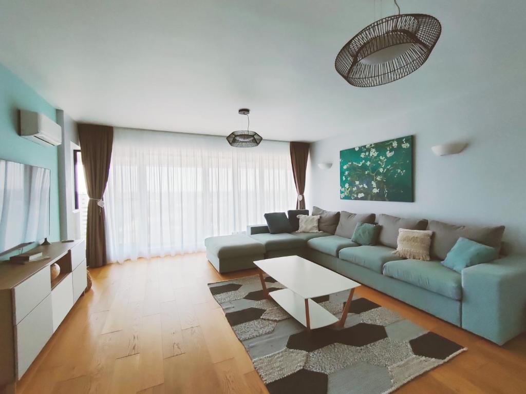 sala de estar con sofá y mesa en Penthouse panoramic, en Chiajna