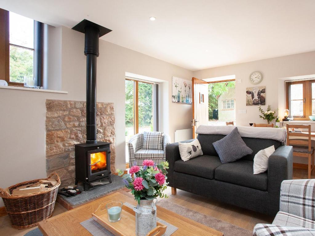 a living room with a couch and a fireplace at Poppy Cottage - Uk31296 