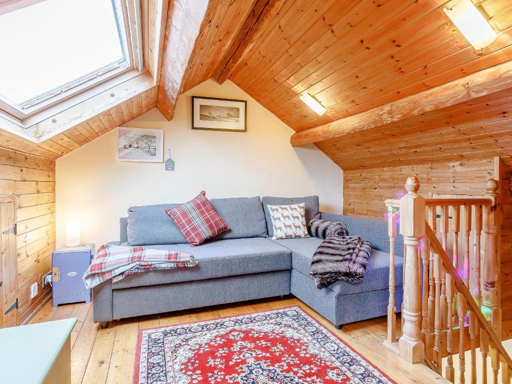 a living room with a couch and a wooden ceiling at The Hayloft in Glossop