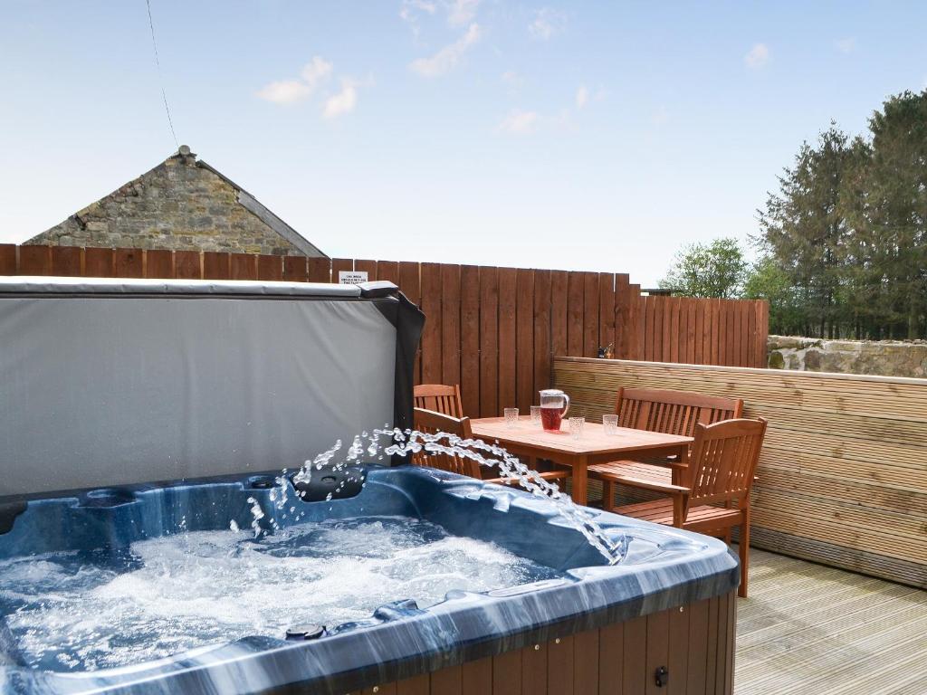 a hot tub on a patio with a table at The Arches - Uk3223 in Linden