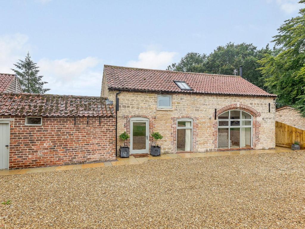 a brick house with a garage and a driveway at The Granary in Hough on the Hill