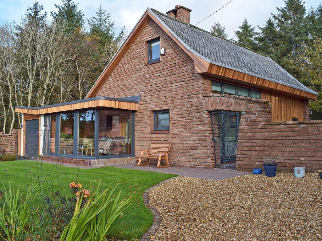 Ein Haus mit einem Backsteinhaus mit einer Terrasse in der Unterkunft Glen Rosa in Dalrymple
