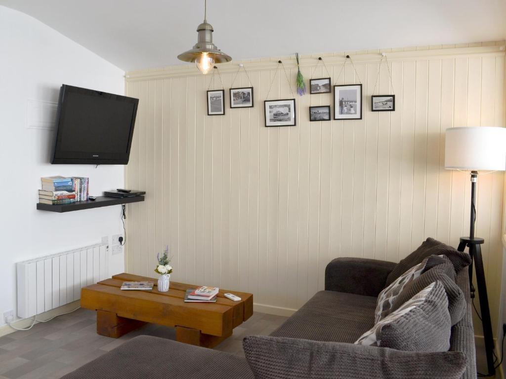 ein Wohnzimmer mit einem Sofa und einem TV in der Unterkunft Coles Retreat in Anderby