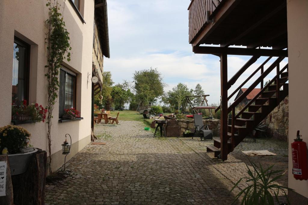eine Gasse zwischen zwei Gebäuden mit einem Tisch und einer Treppe in der Unterkunft Ferienwohnung Brunow "In der Natur Zuhause" in Neundorf
