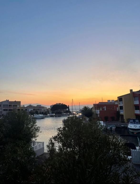 un coucher de soleil sur un port avec des bateaux dans l'eau dans l'établissement Appartement sur Le Barcares, au Barcarès