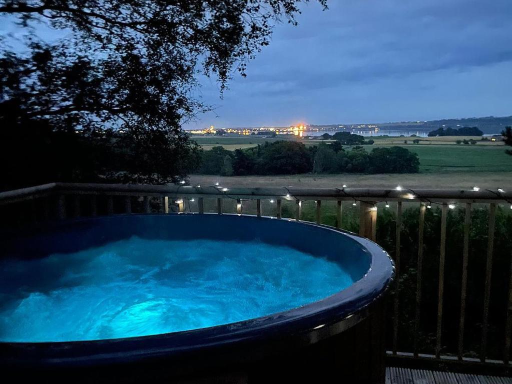 a hot tub with blue water in a fence at Goose View in Montrose