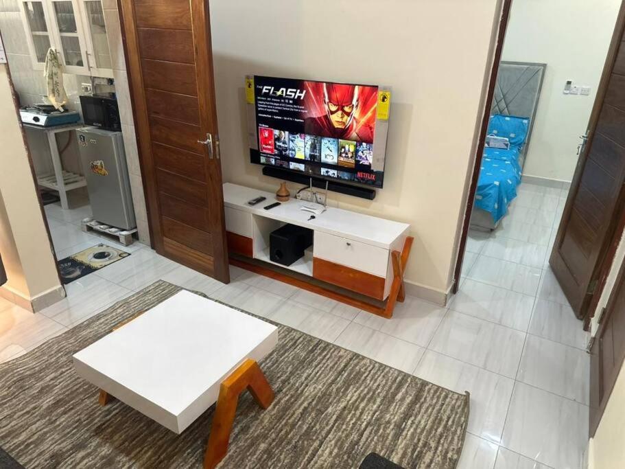 a living room with a flat screen tv and a table at BlissNest in Dar es Salaam