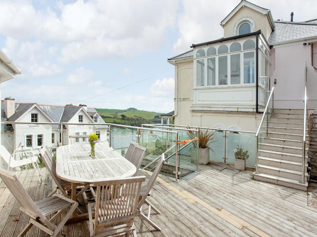 eine Holzterrasse mit einem Tisch und Stühlen auf einem Haus in der Unterkunft Muffins in Salcombe