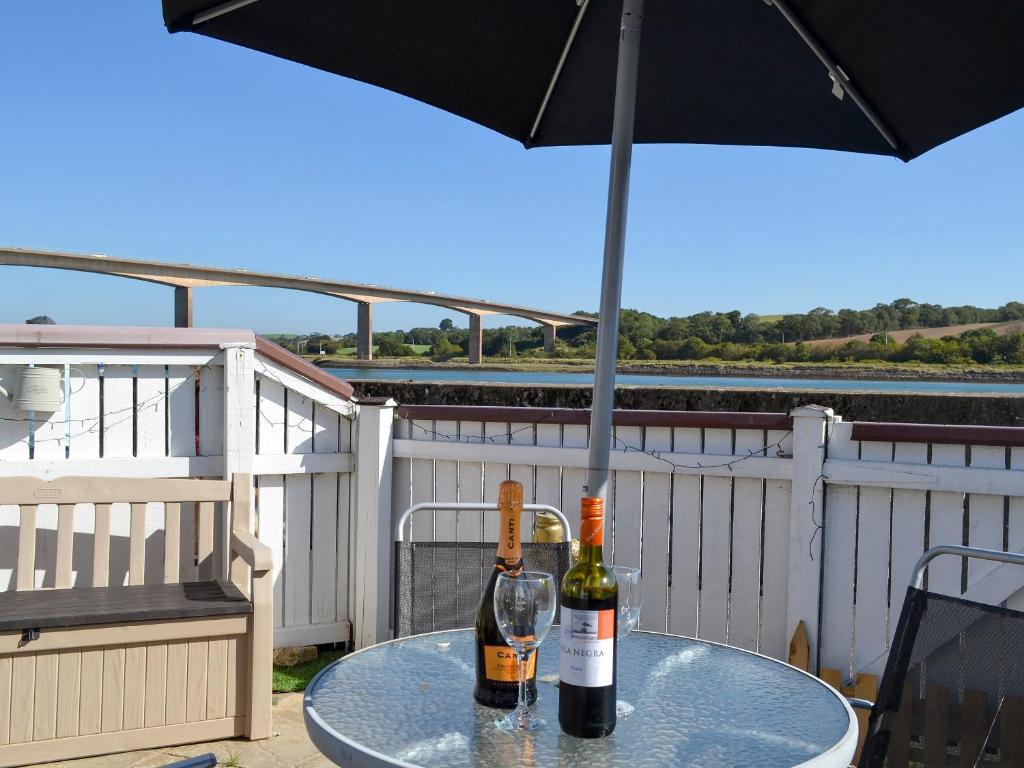 dos botellas de vino en una mesa con sombrilla en Mariners Rest, en Bideford