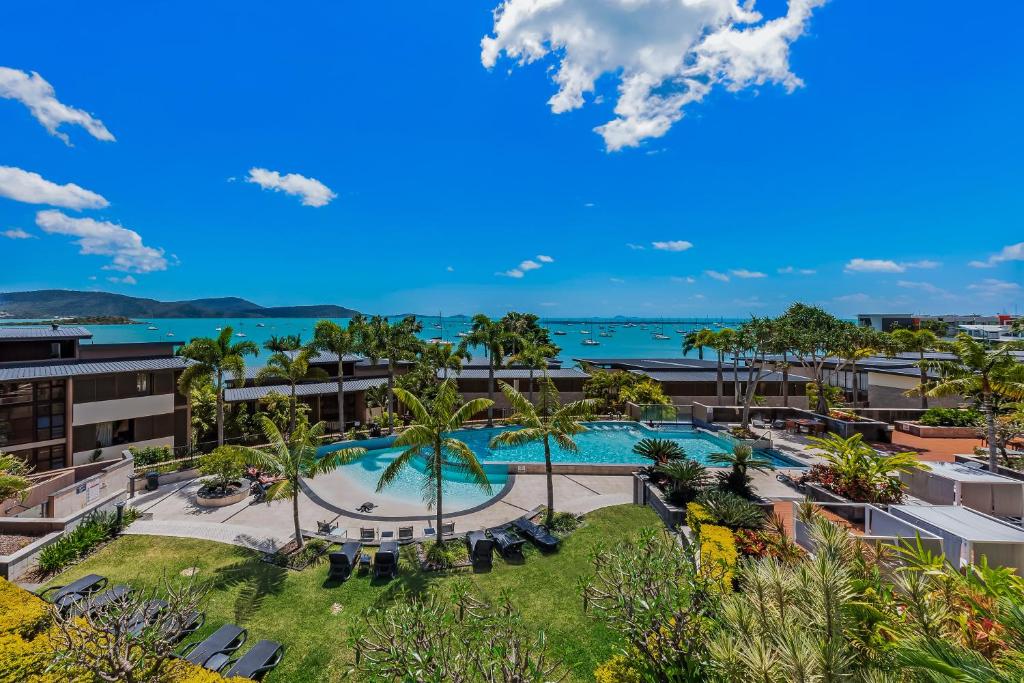 an aerial view of a resort with a pool and the ocean at Mirage Whitsundays in Airlie Beach
