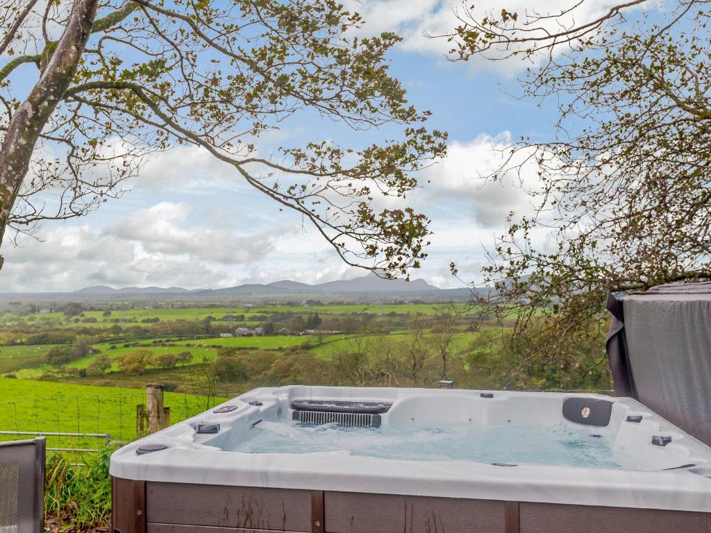 a hot tub with a view of a field at Dutch Barn Two - Uk12873 in Brynkir