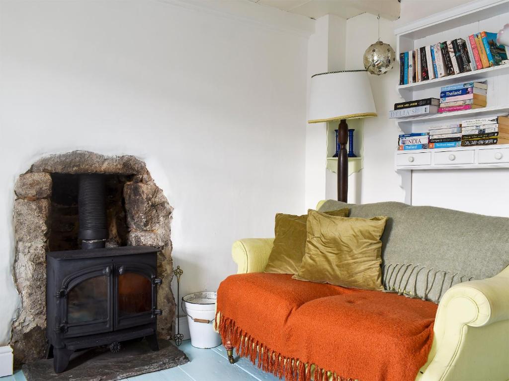 a living room with a couch and a wood stove at The Cottage in St Ives