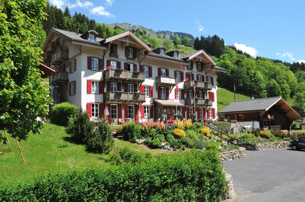 Una casa grande con un jardín enfrente. en Historic Hotel du Pillon, en Les Diablerets