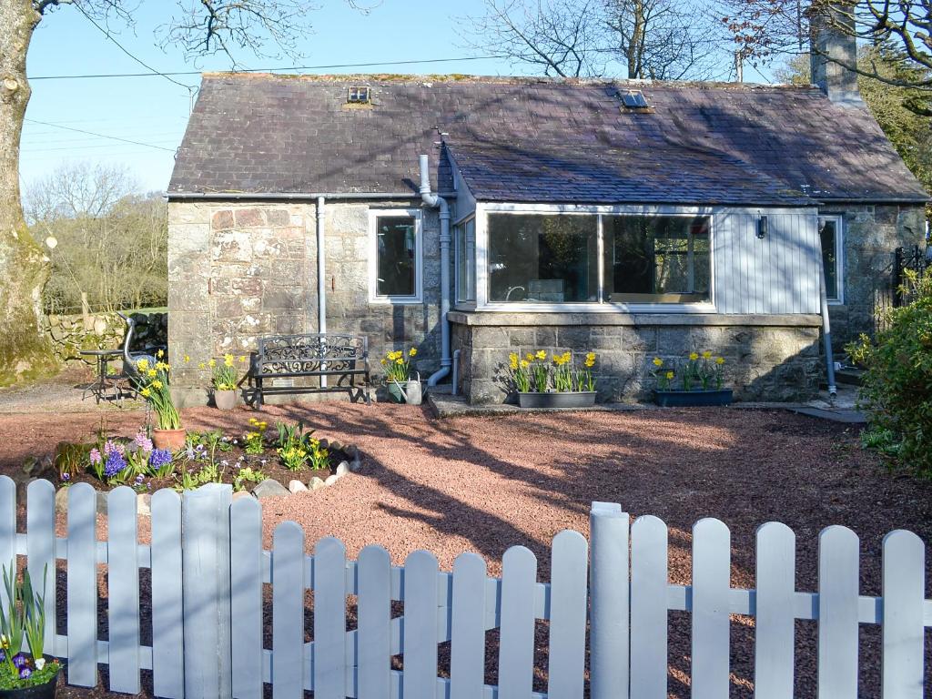 a white picket fence in front of a house at Craigrannoch Cottage in Rockcliffe
