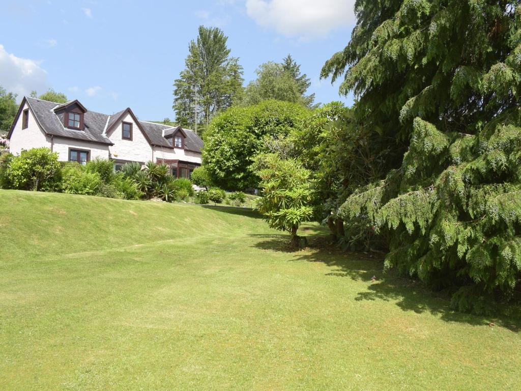 una casa en una colina con un patio verde en Cluniter Cottage, en Innellan