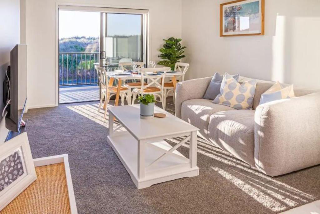 - un salon avec un canapé et une table dans l'établissement Beach Front Abode- 2 Bed 2 Bath, à Christchurch