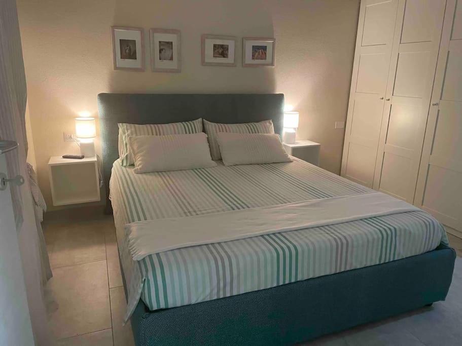 ein Schlafzimmer mit einem großen Bett mit zwei Kissen in der Unterkunft La magia del mare in Sardegna (I.U.N. Q5901) in Iglesias