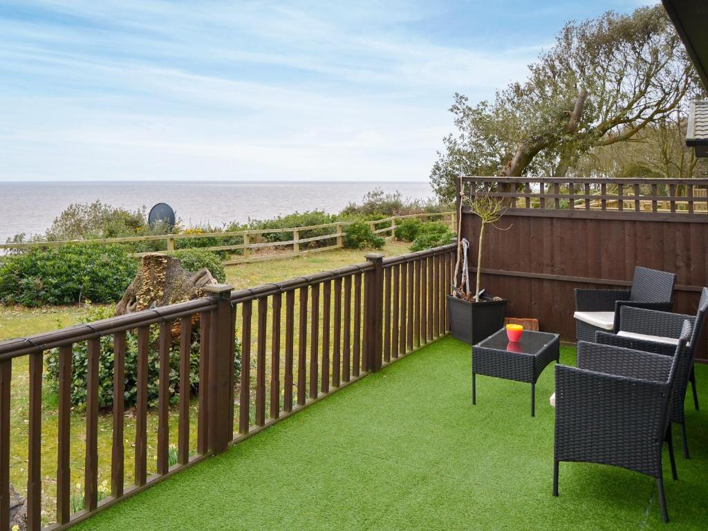 a balcony with chairs and a table and the ocean at Ocean Glade - Uk32963 in Corton