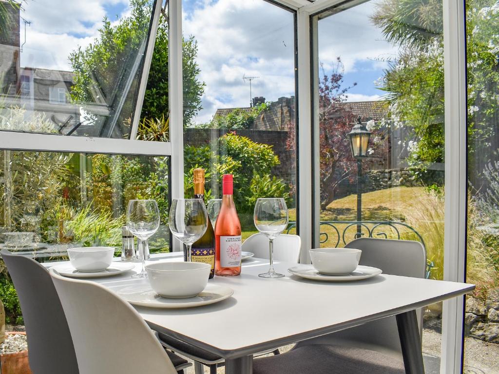 una mesa con copas y una botella de vino en Garden Flat en Ryde
