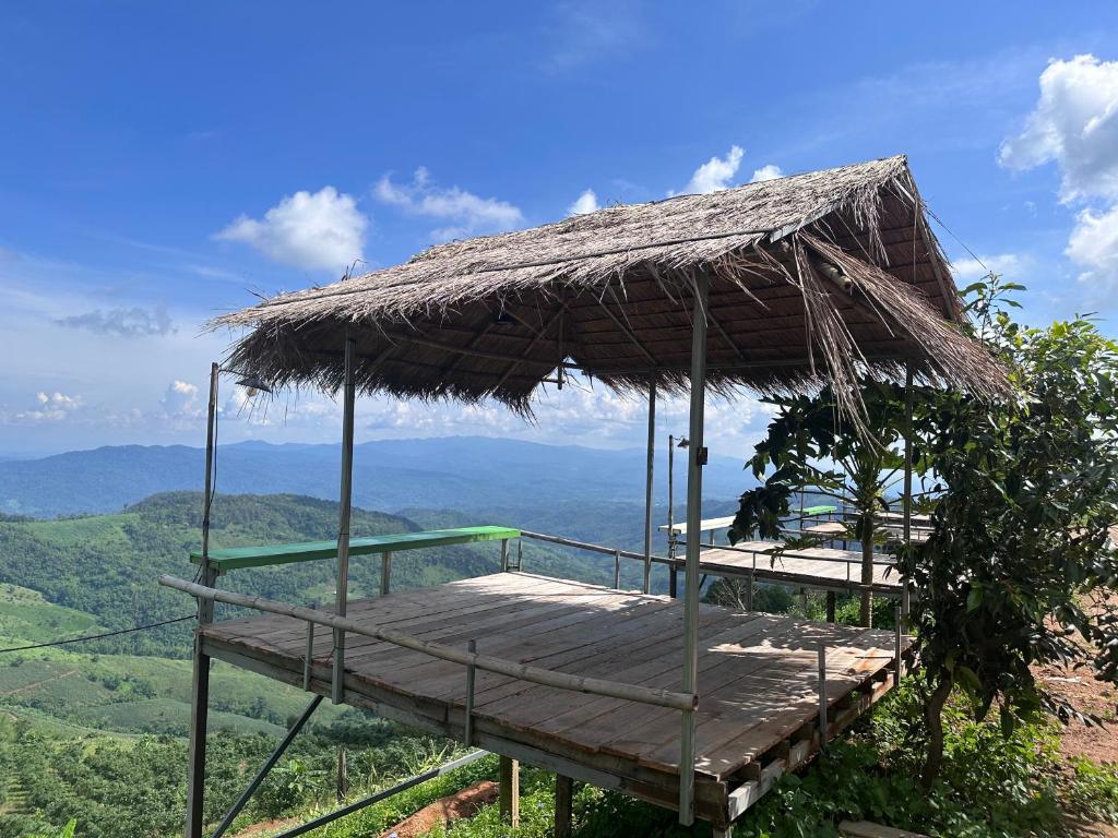 een bed in een rieten paraplu op de top van een berg bij อาข่าภูมา-Akha Phuma 