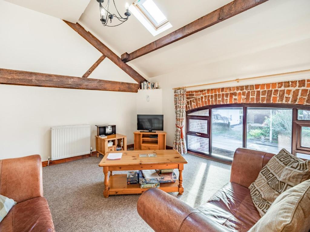 a living room with a couch and a table at The Hay Loft in Poulton le Fylde