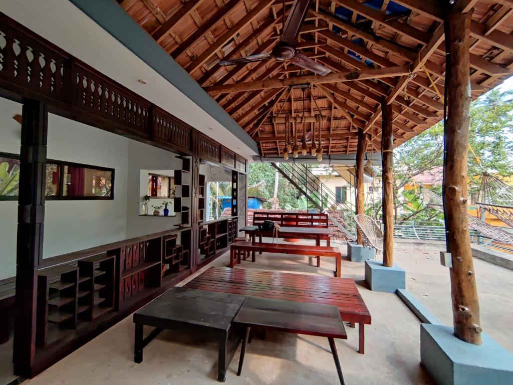 a patio with benches and tables in a building at Munroeisland Backwaters Homestay in Munroe Island