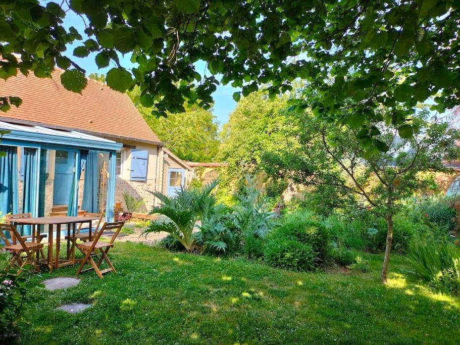 d'un jardin avec une table et des chaises dans la pelouse. dans l'établissement Gîte des Cornettes, à Écardenville-sur-Eure