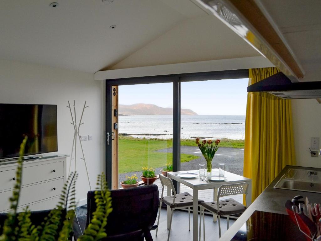 a kitchen with a table and a view of the ocean at The Isle View Nest - Uk13547 in Broadford