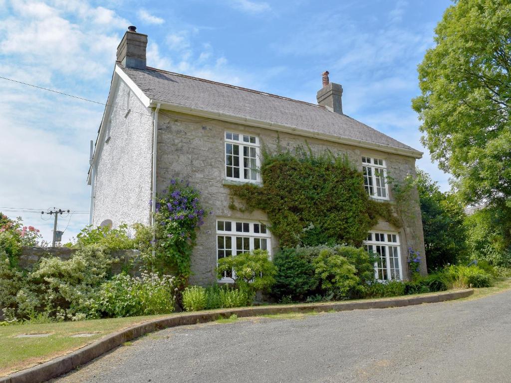 uma velha casa de pedra ao lado de uma estrada em Lordship Farmhouse em Saint Lawrence