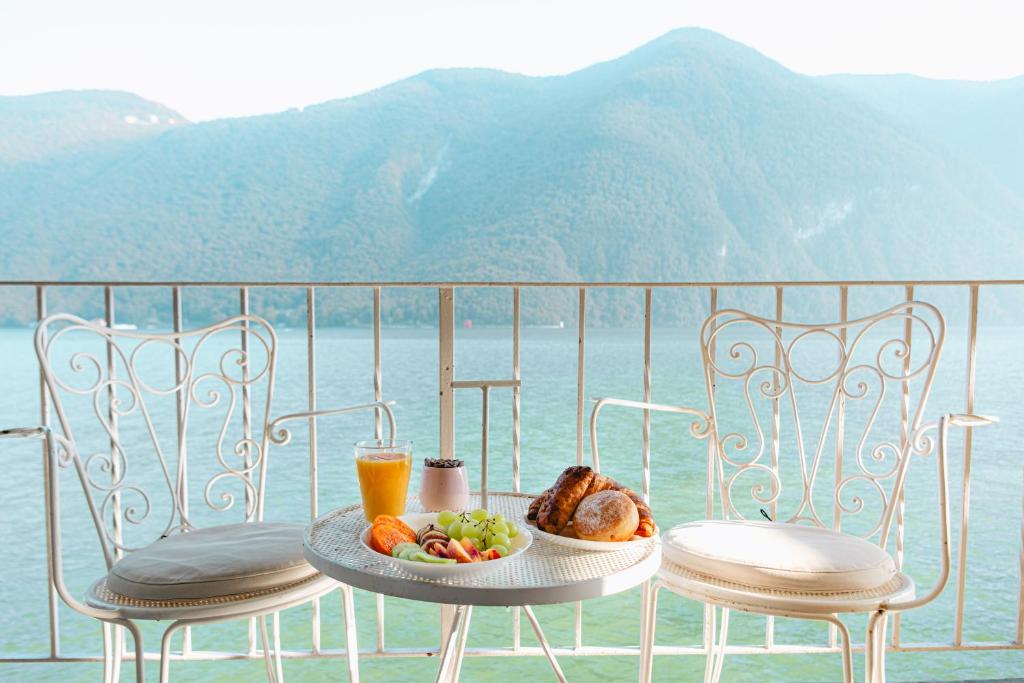 a table with a plate of food and a glass of orange juice at [Lake 5* Gandria] - Antico Approdo in Lugano