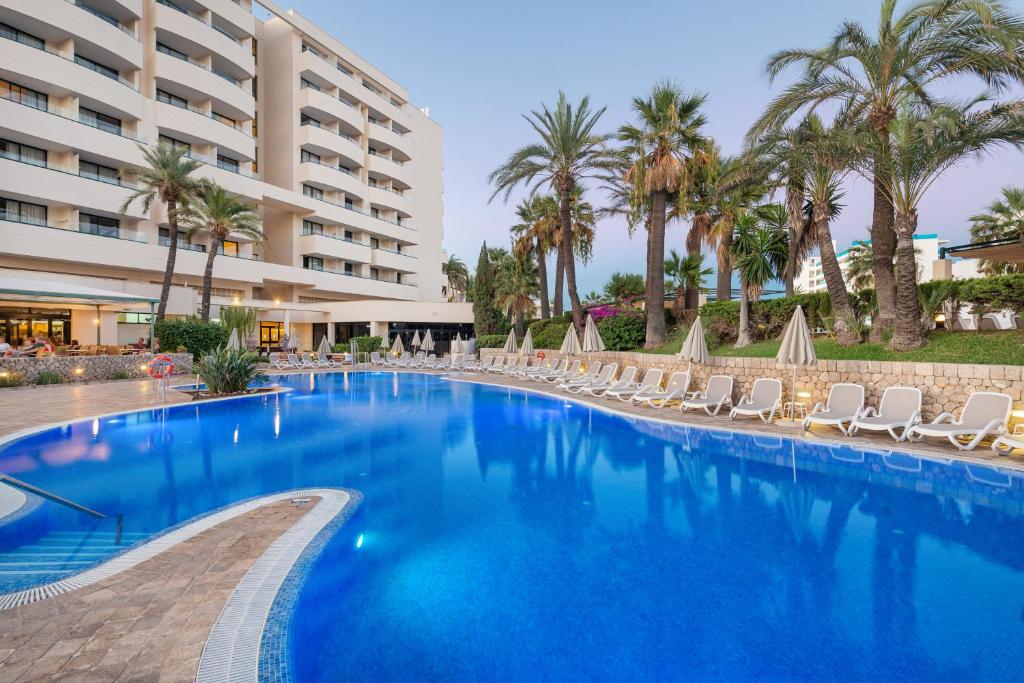 薩科馬的住宿－Welikehotel Marfil Playa，一个带椅子的大型游泳池和一间酒店