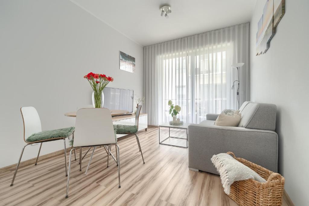 - un salon avec un canapé, une table et des chaises dans l'établissement Apartament Doris 2 - 50 m do plaży, à Pobierowo