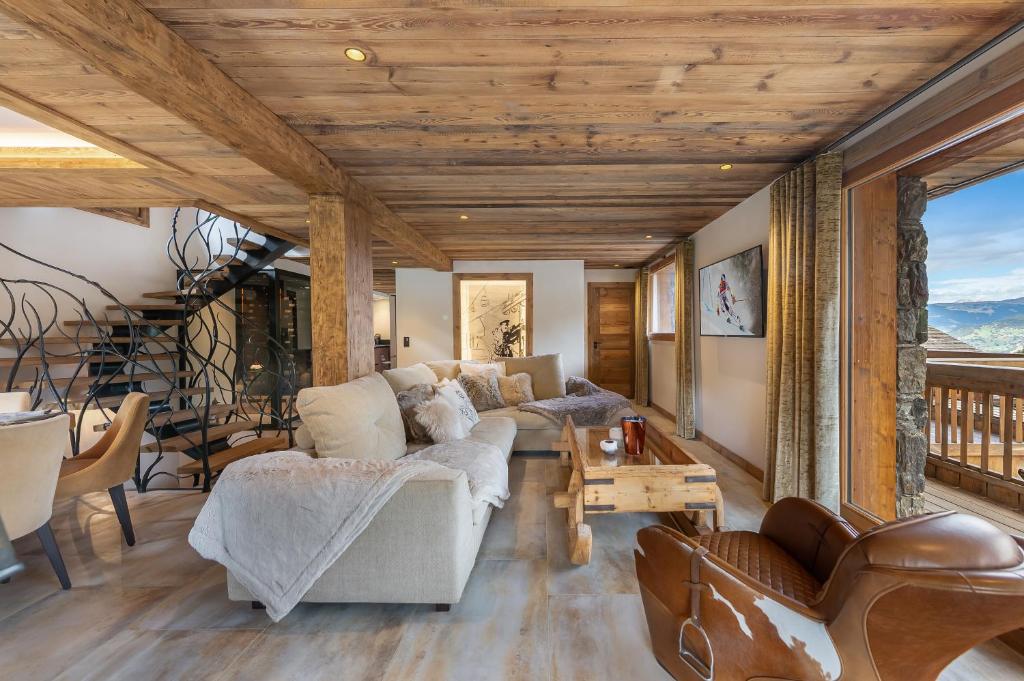 a living room with a couch and a table at Le Cheval Blanc Luxe, skis aux pieds, jacuzzi, hammam, salle de cinéma in Les Allues