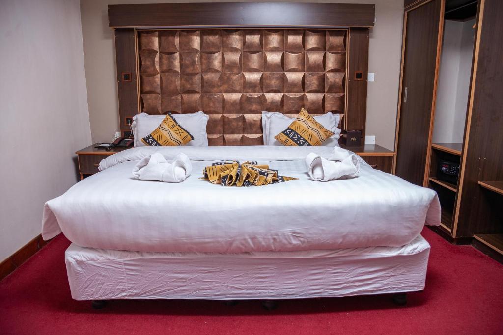 Postel nebo postele na pokoji v ubytování The Luke Hotel Cravers Thika