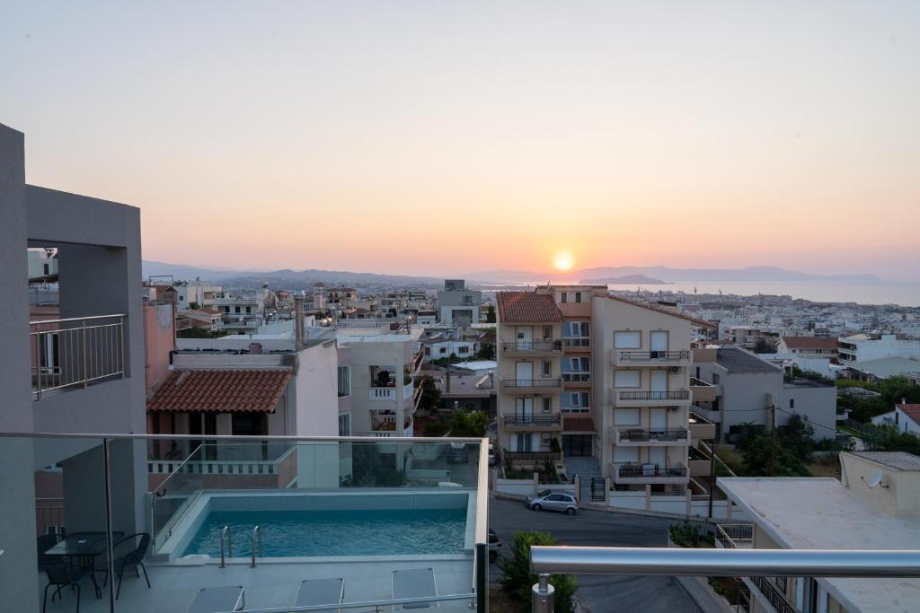 een uitzicht op de zonsondergang vanaf het balkon van een gebouw bij EDEL Suite in Chania