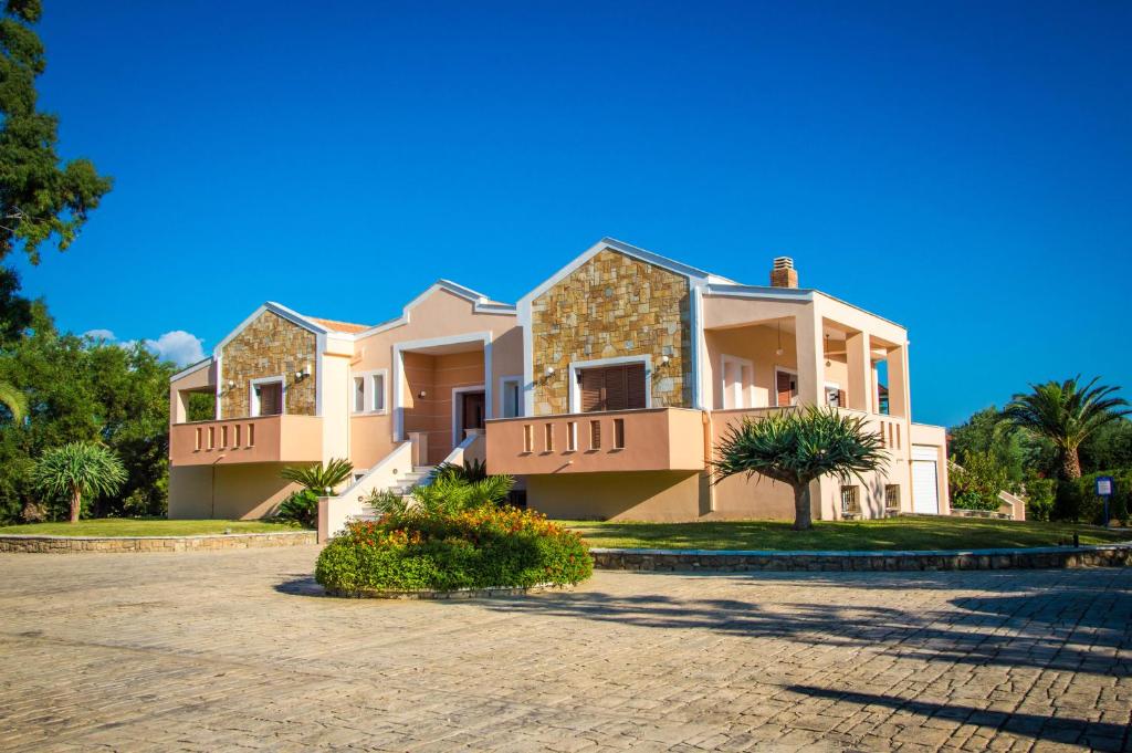 una grande casa con un vialetto davanti di Leone Luxury Villas a Kalamákion