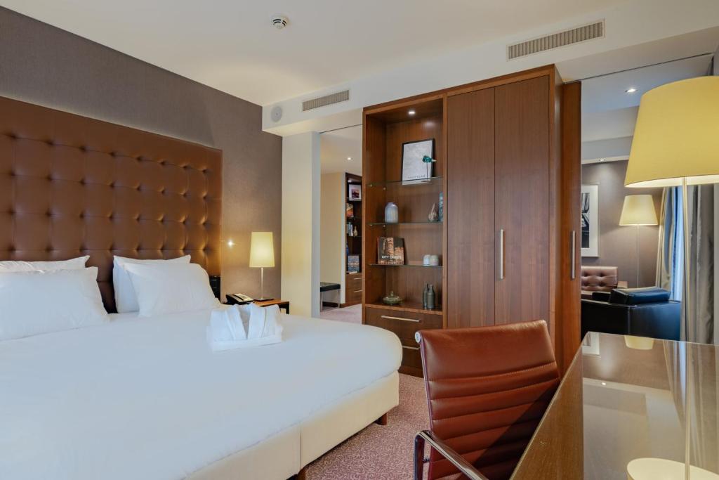 um quarto de hotel com uma cama e uma cadeira em Crowne Plaza Amsterdam - South, an IHG Hotel em Amesterdão