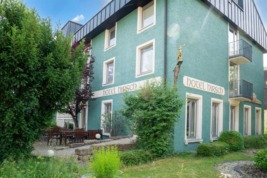 Un bâtiment bleu avec un besoin aigu écrit sur lui dans l'établissement Hotel Hirsch, à Heidenheim an der Brenz