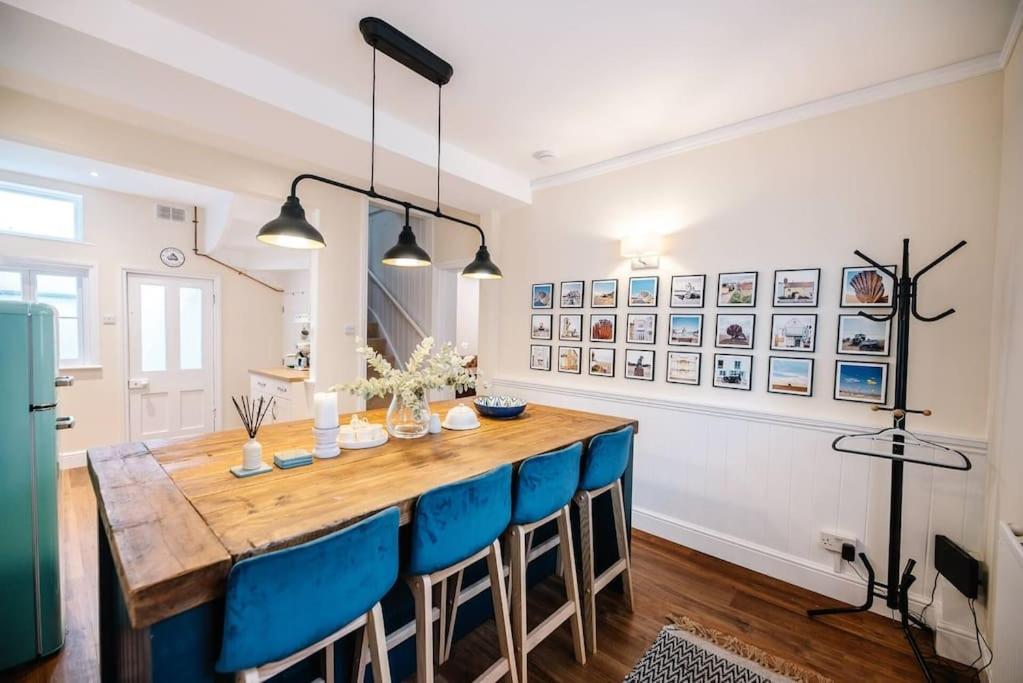 a dining room with a wooden table and blue chairs at Seaway Cottage, Aldeburgh in Aldeburgh