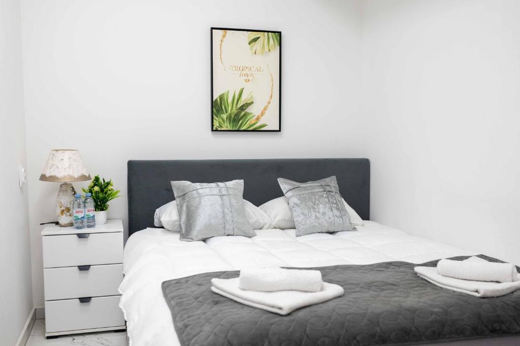 1 dormitorio con 1 cama blanca grande y toallas. en The Sun Apartments Brcko, en Brčko