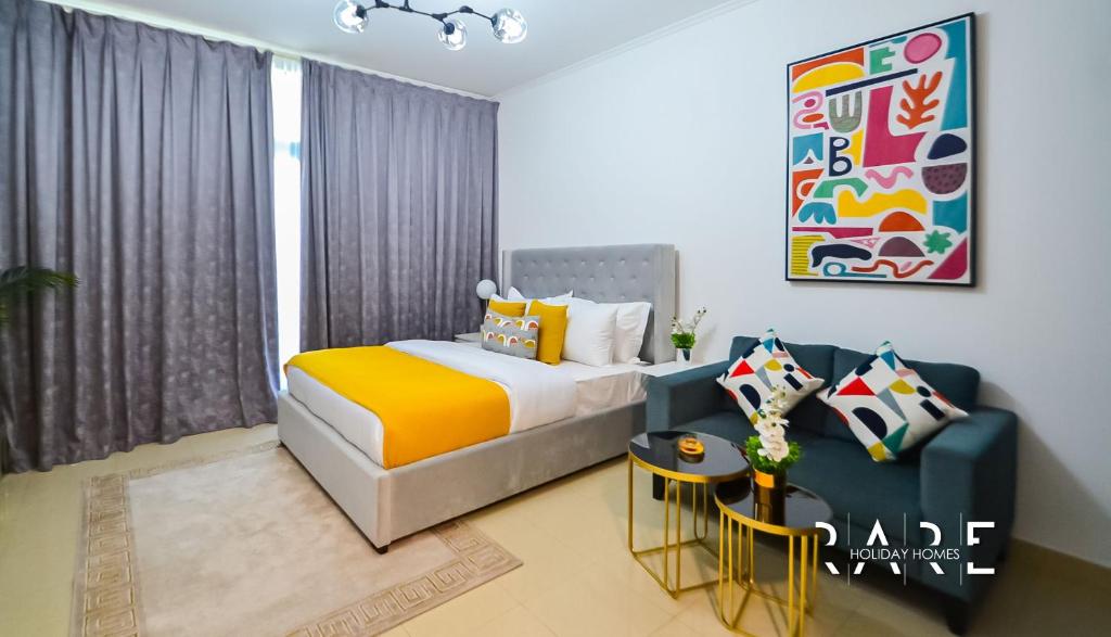 a bedroom with a bed and a couch at Rare Holiday Homes welcomes you in - Canal View - The links canal Apartment R304 in Dubai